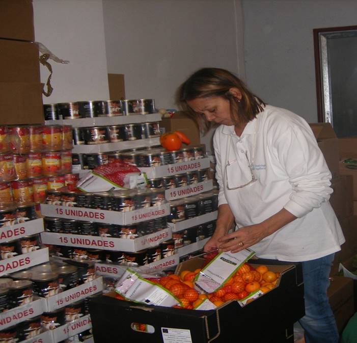 Mujer voluntaria preparando cajas de alimentos con productos básicos en el Banco de Recursos del Centre Sant Martí.
